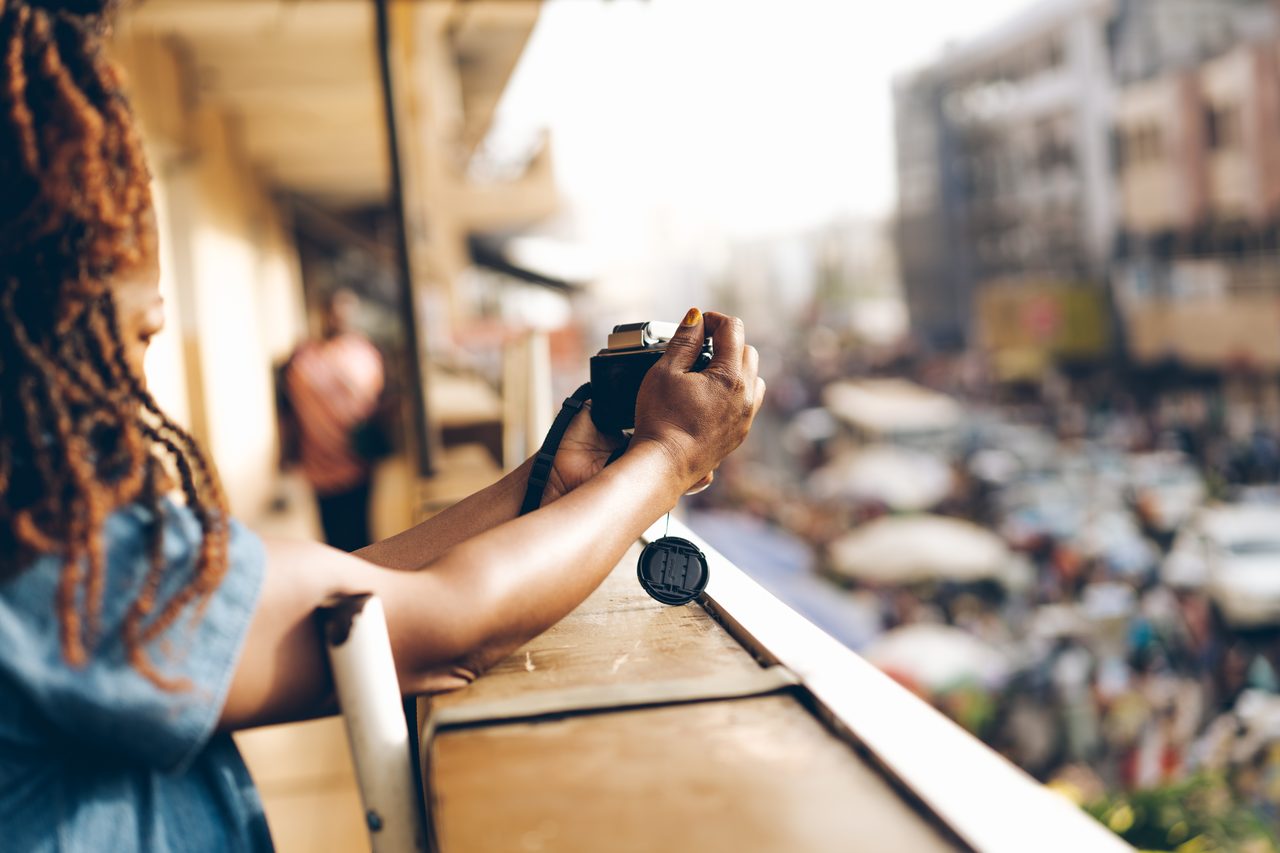 A communicator photographing a busy market from a balcony above
